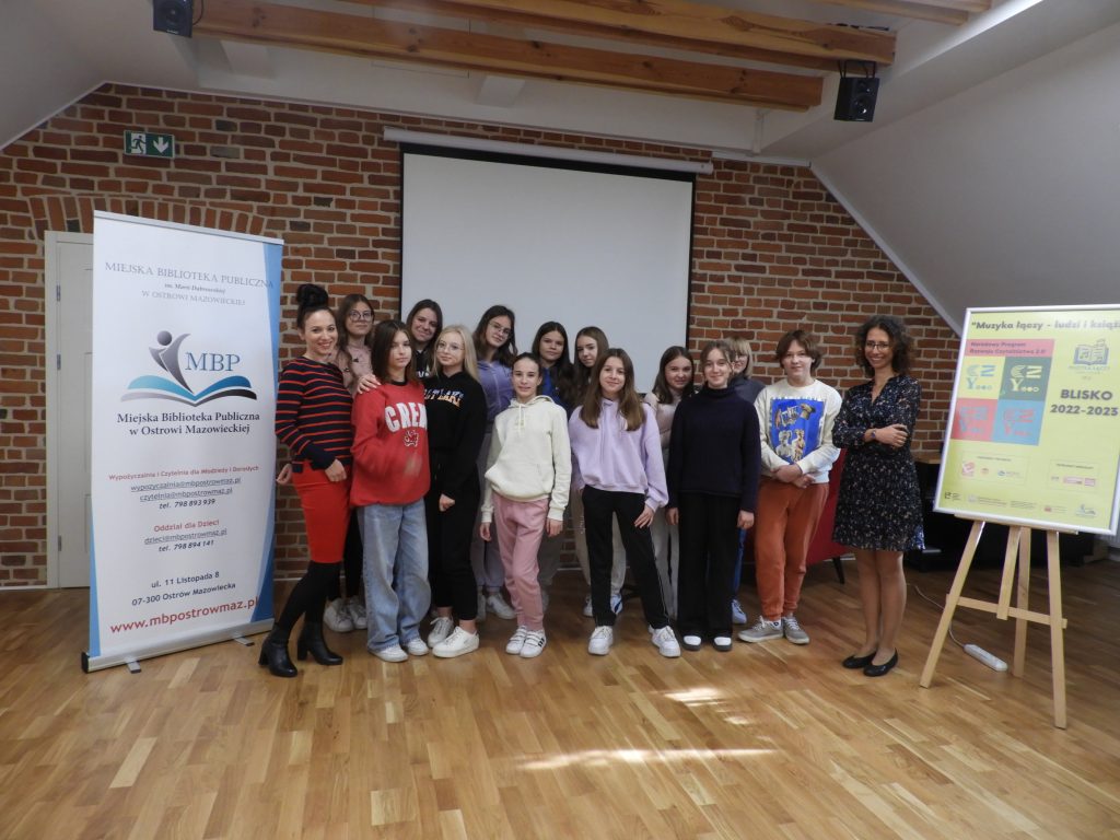 Na zdjęciu jest 15 osób w tym nauczycielka i prowadząca warsztaty Marta Kawalec, po lewej rolap bibliotek, po prawej plakat Programu Bliskoi