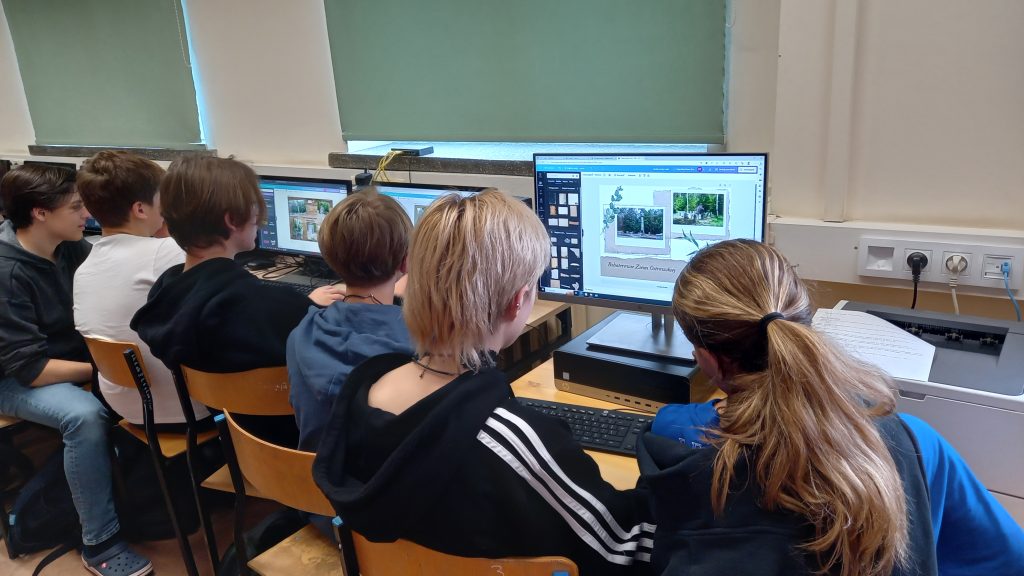 Na zdjęciu grupa młodzieży- siedzą przy komputerach.